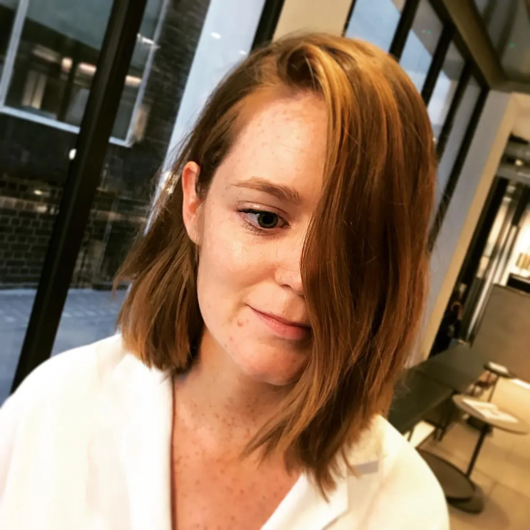 Angled auburn side-part lob with smooth finish