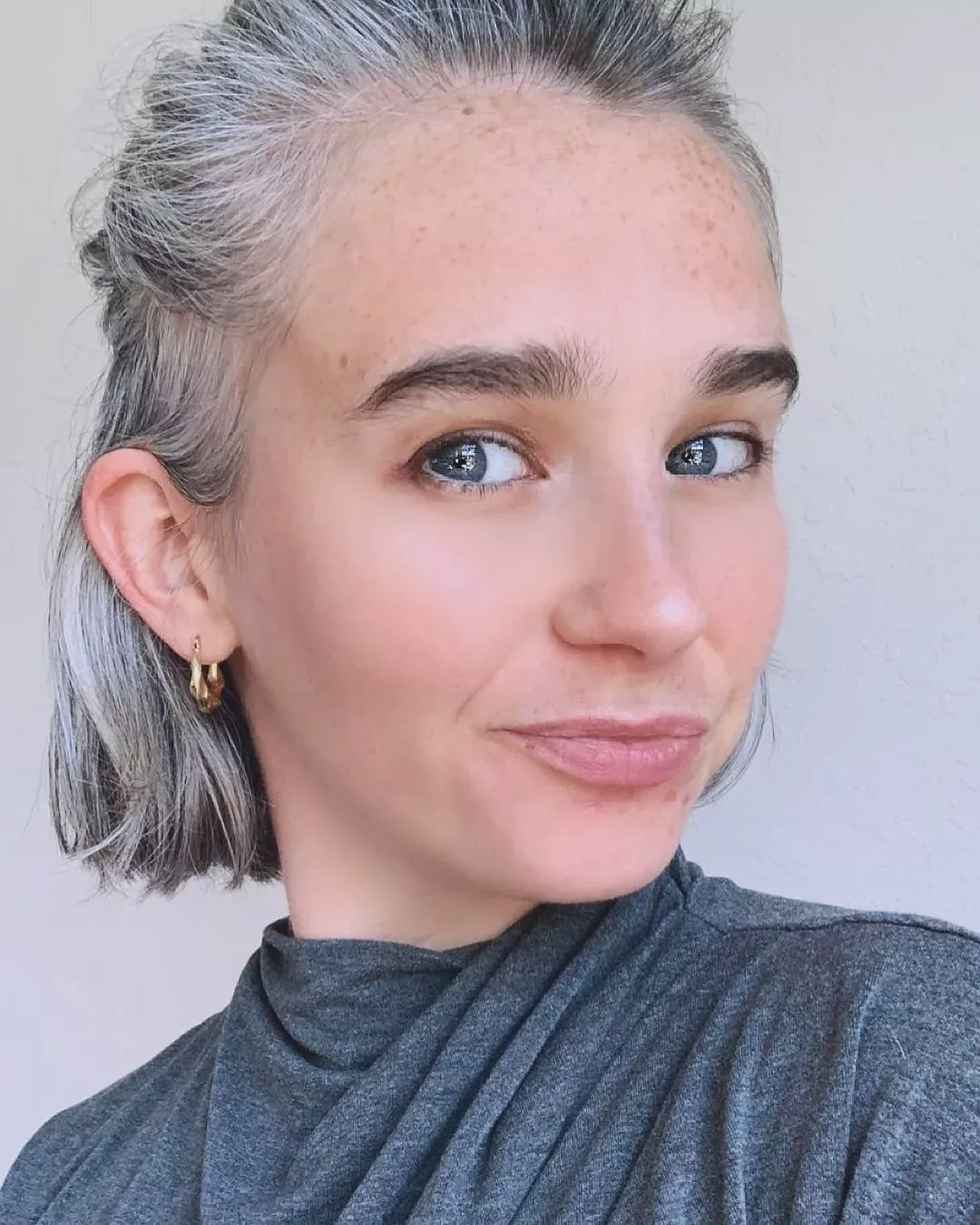Silver hair pulled into a low ponytail