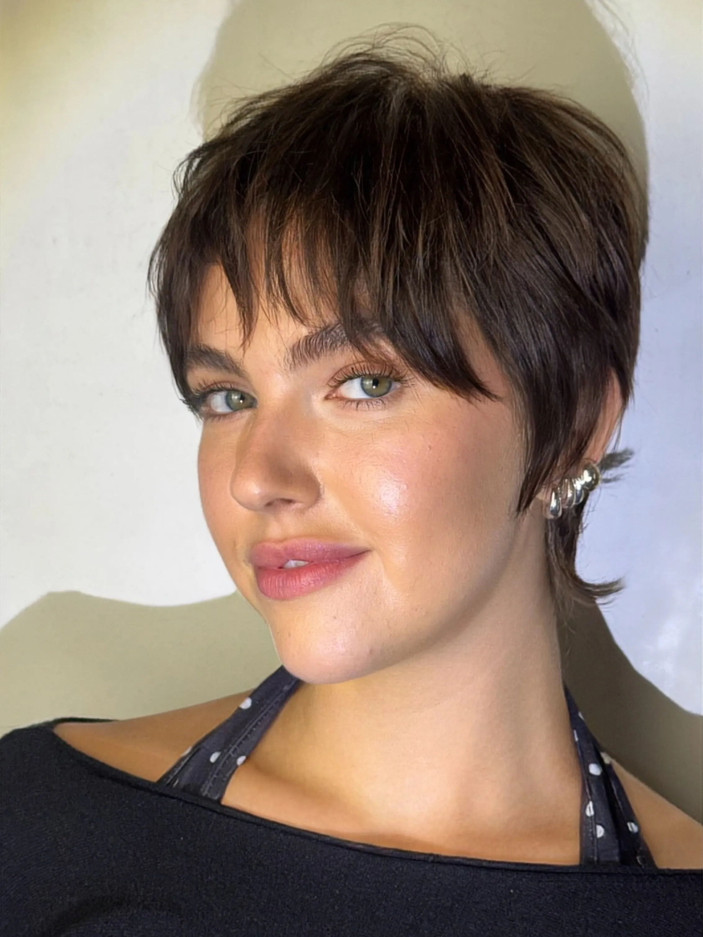Dark rounded pixie with long smooth fringe around the forehead