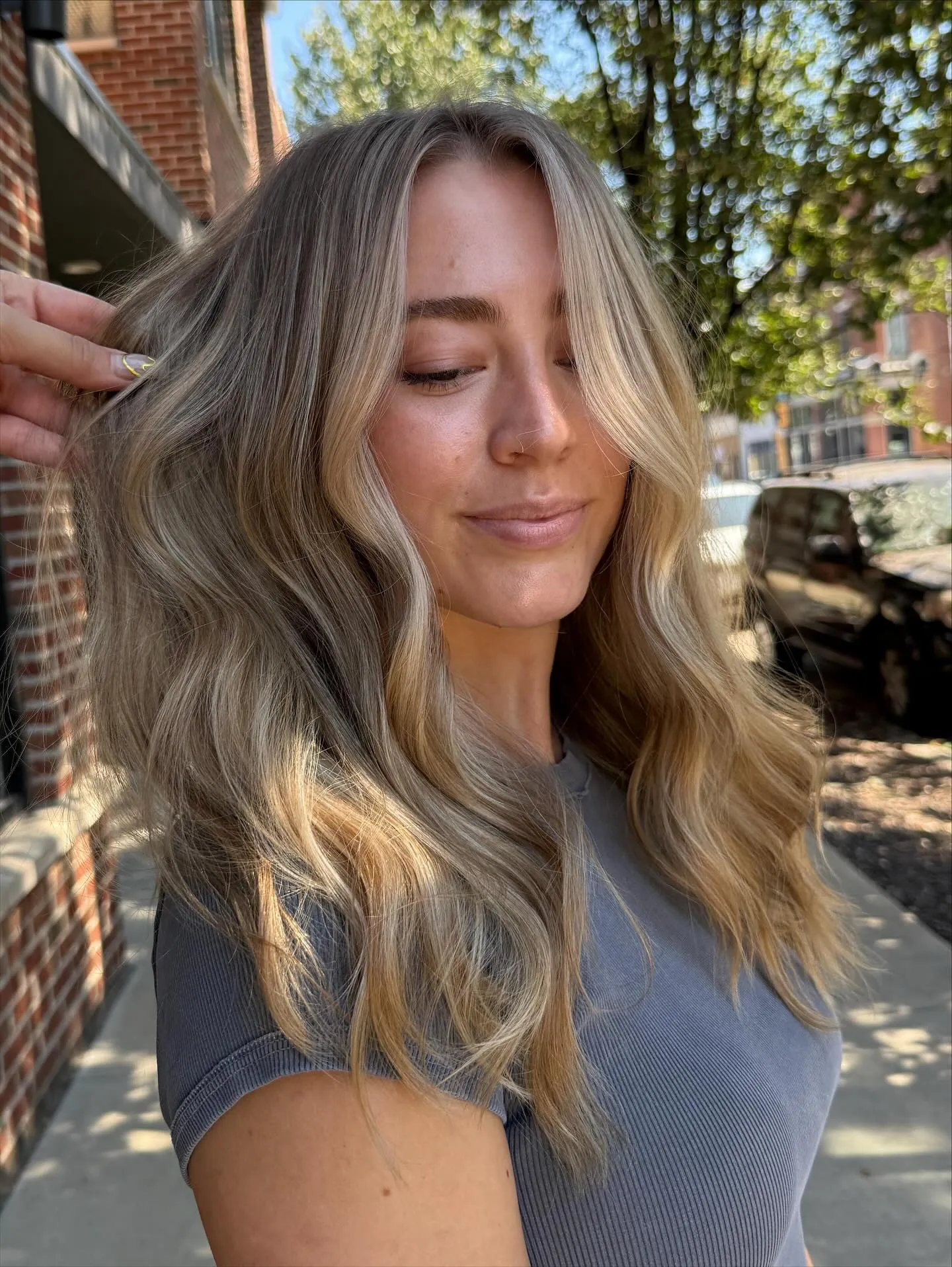 Wavy suede blonde balayage with darker roots and soft highlights