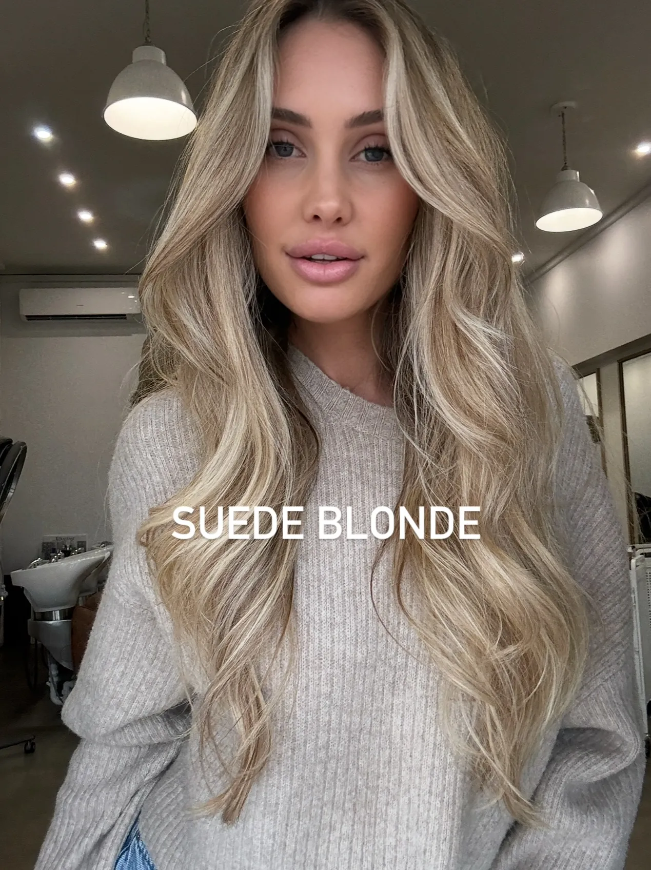 Long suede blonde waves with soft center part and blended highlights