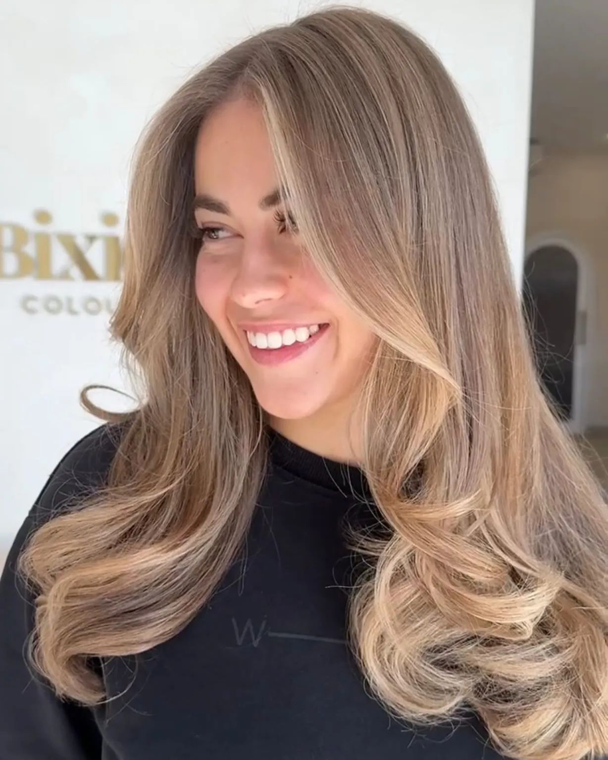 Polished suede blonde blowout with rounded face-framing layers