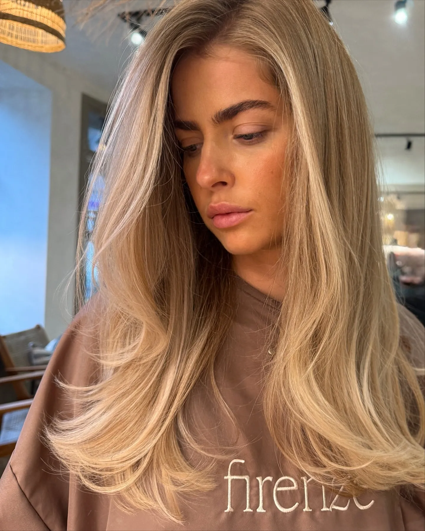 Long suede blonde layers swept to one side with curved ends