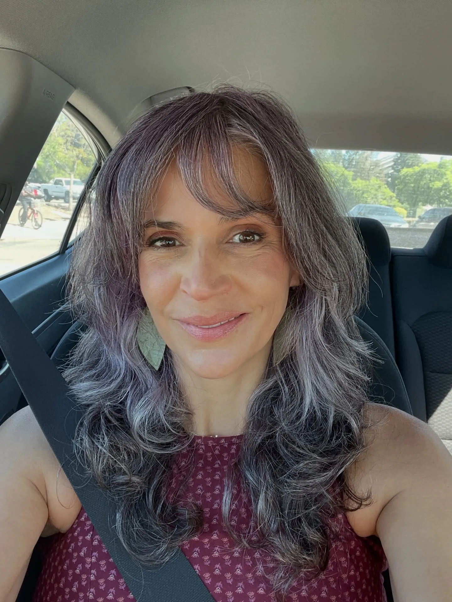 Long layered gray hair with wispy bangs and soft waves