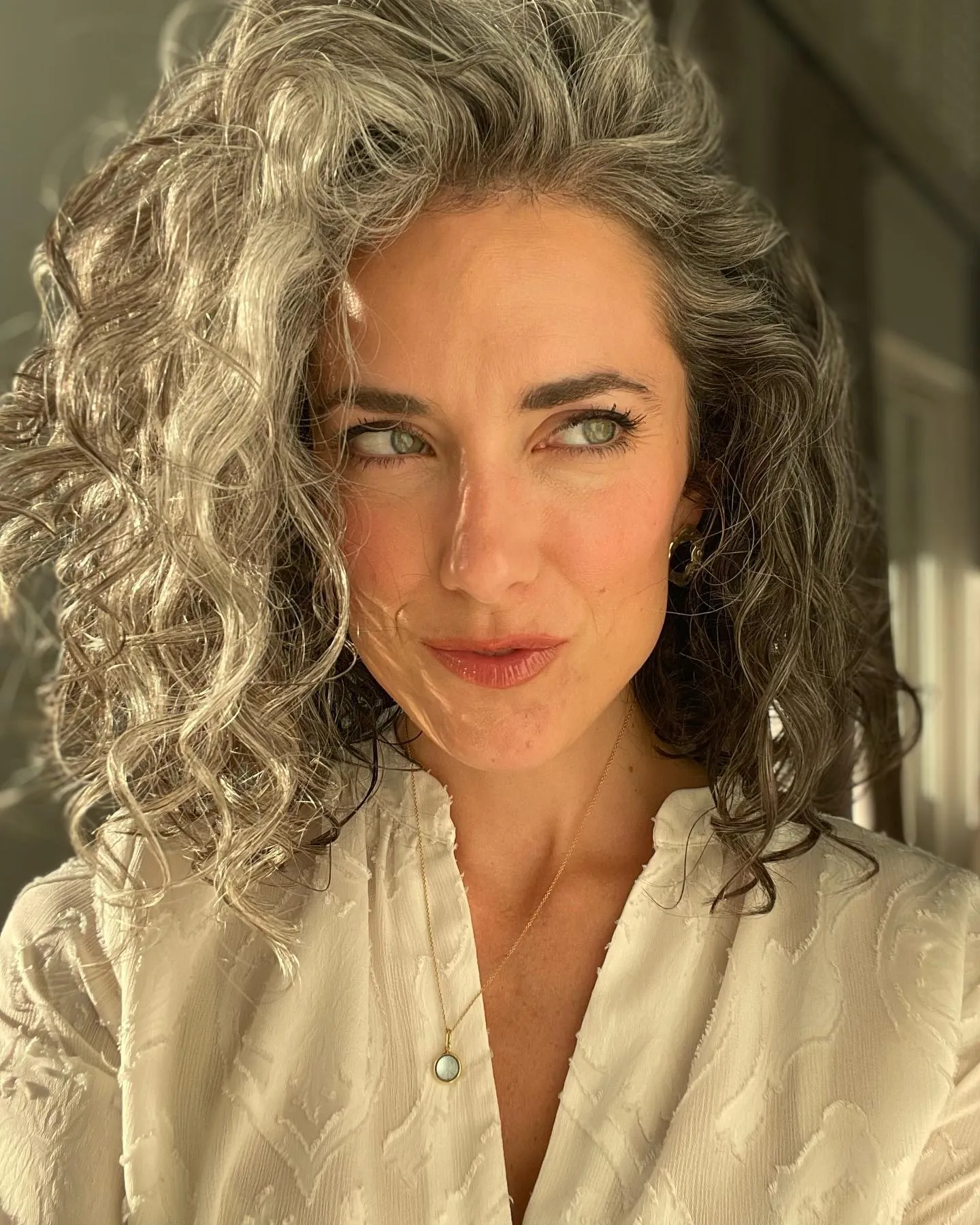 Side-parted gray curly bob with defined curls