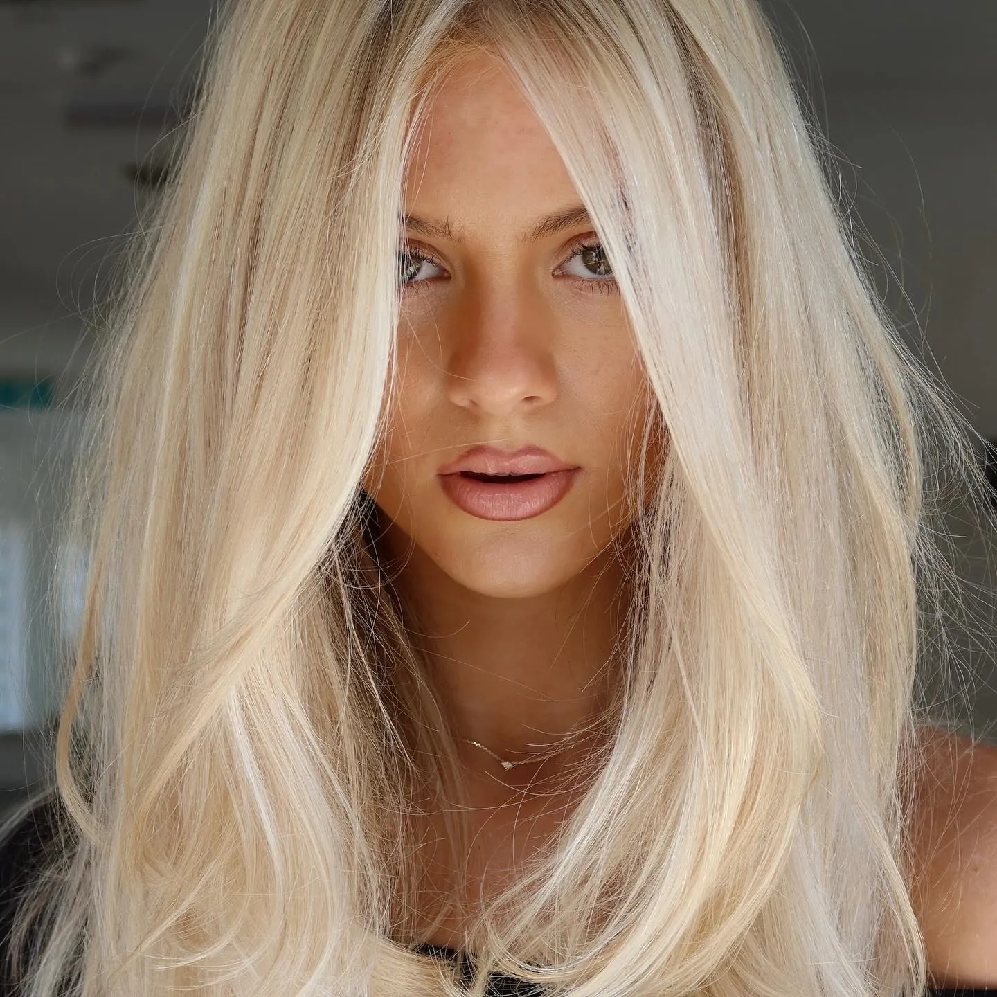 Long bright blonde hair with centre part and soft layers