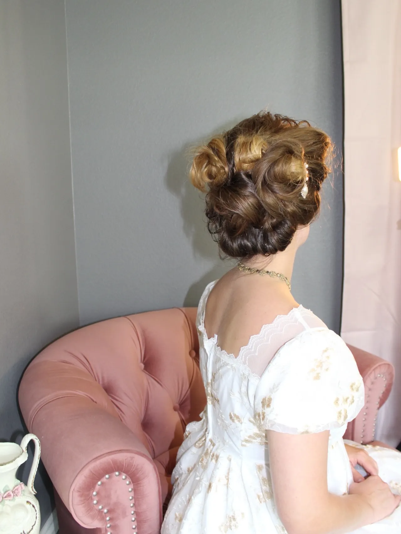Victorian-inspired coiled bun with rolled sections at the back