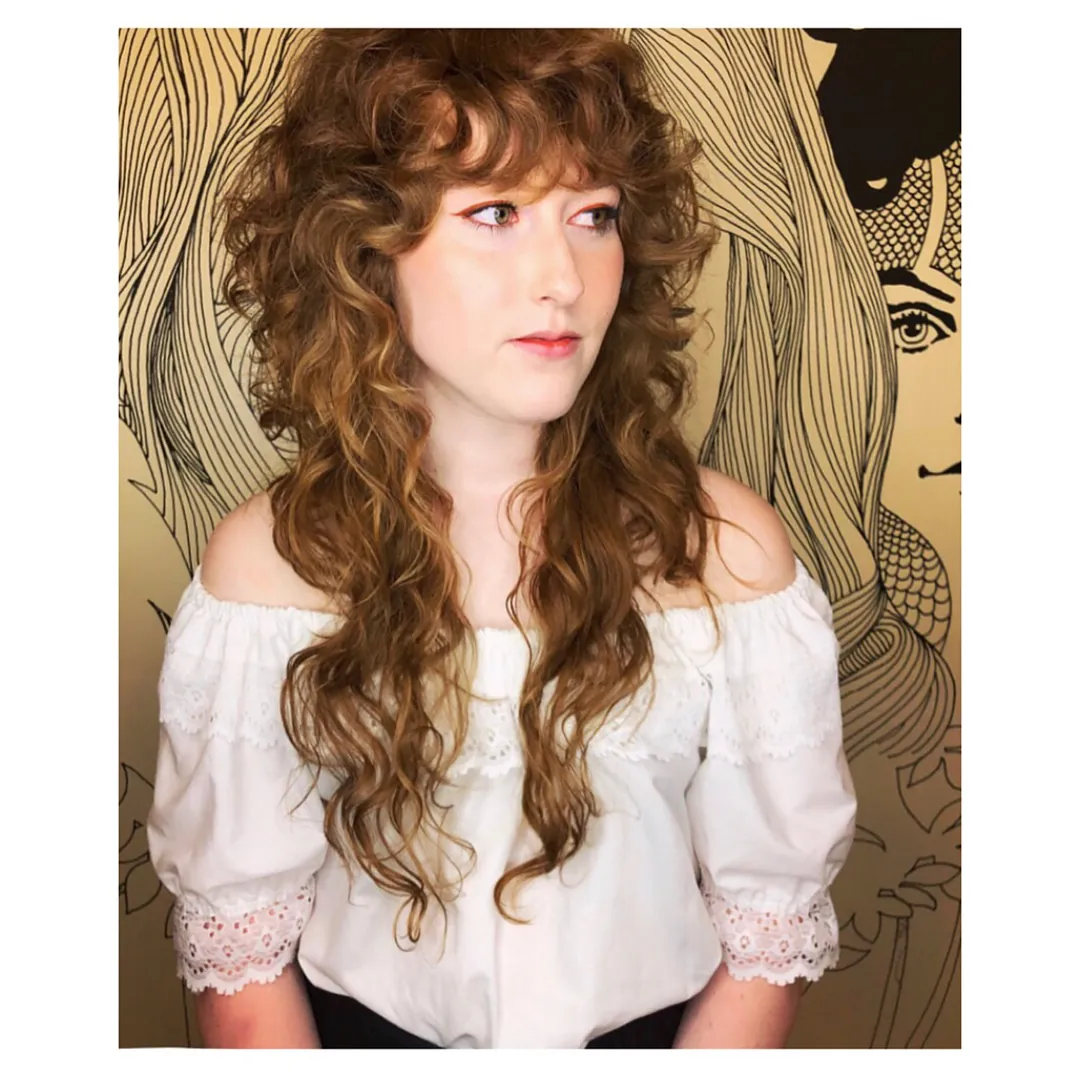 Long loose Victorian-inspired curls with full soft fringe