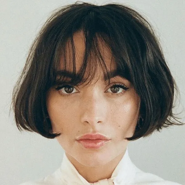 Short dark French bob with wispy fringe and rounded ends