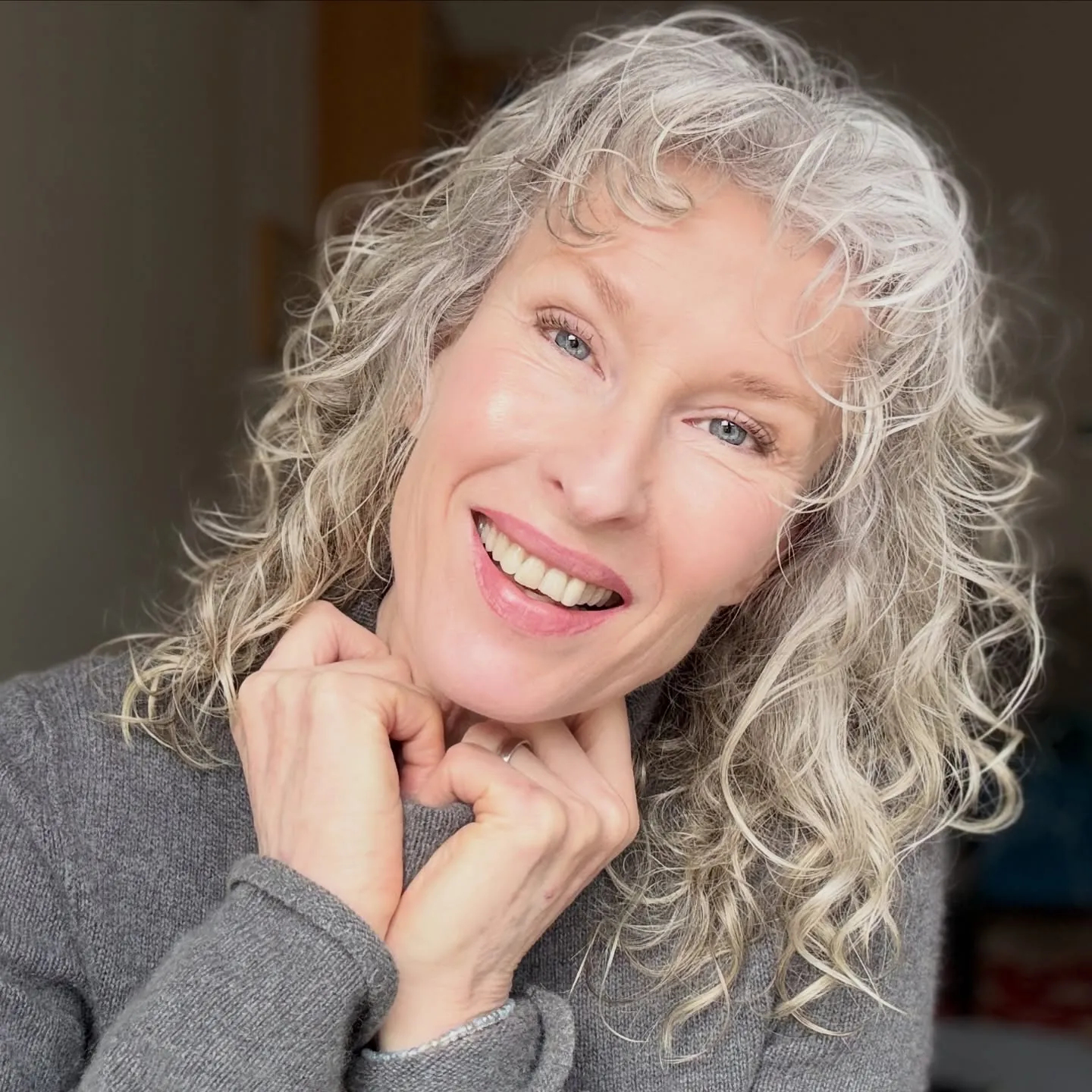 Shoulder-length silver curls with soft face-framing layers