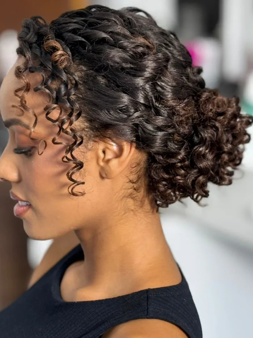 Braided curly low bun with defined face-framing curls