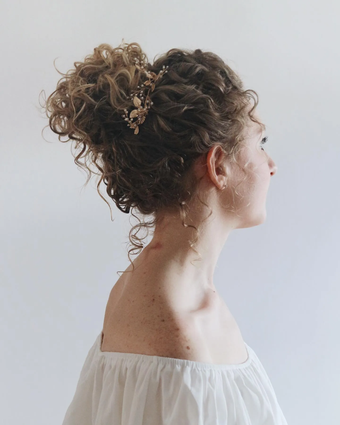 High curly updo with a delicate jeweled hairpiece