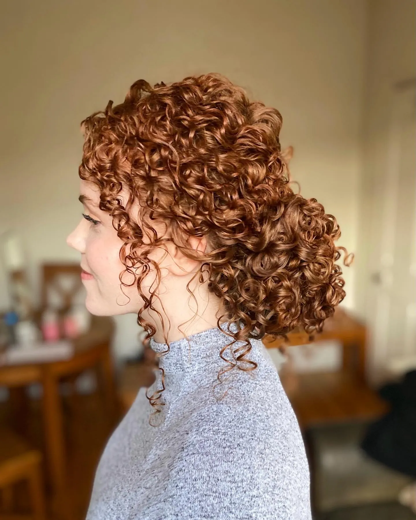 Side-swept curly ponytail with defined ringlets
