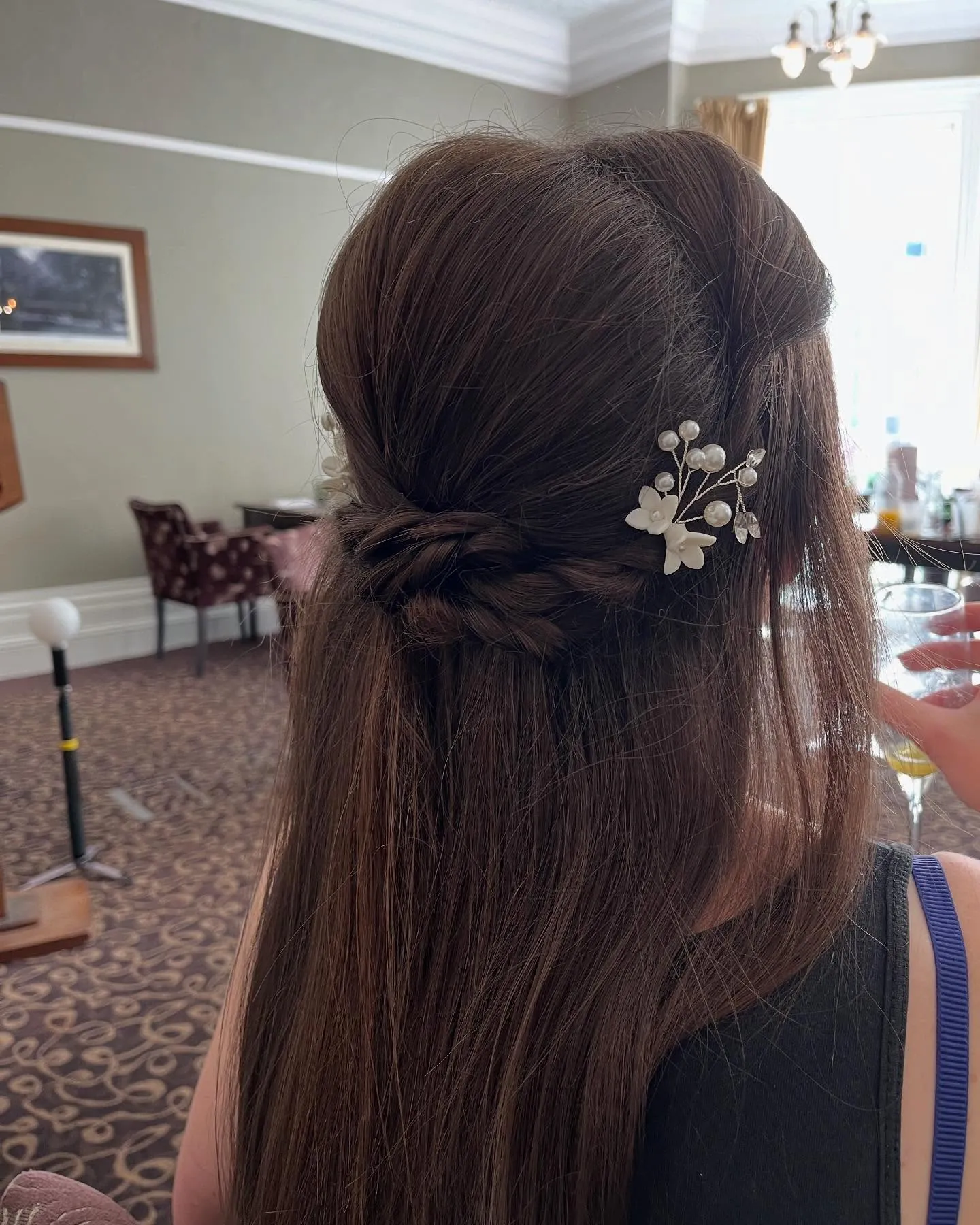 Straight half-up hairstyle with braid and floral pin