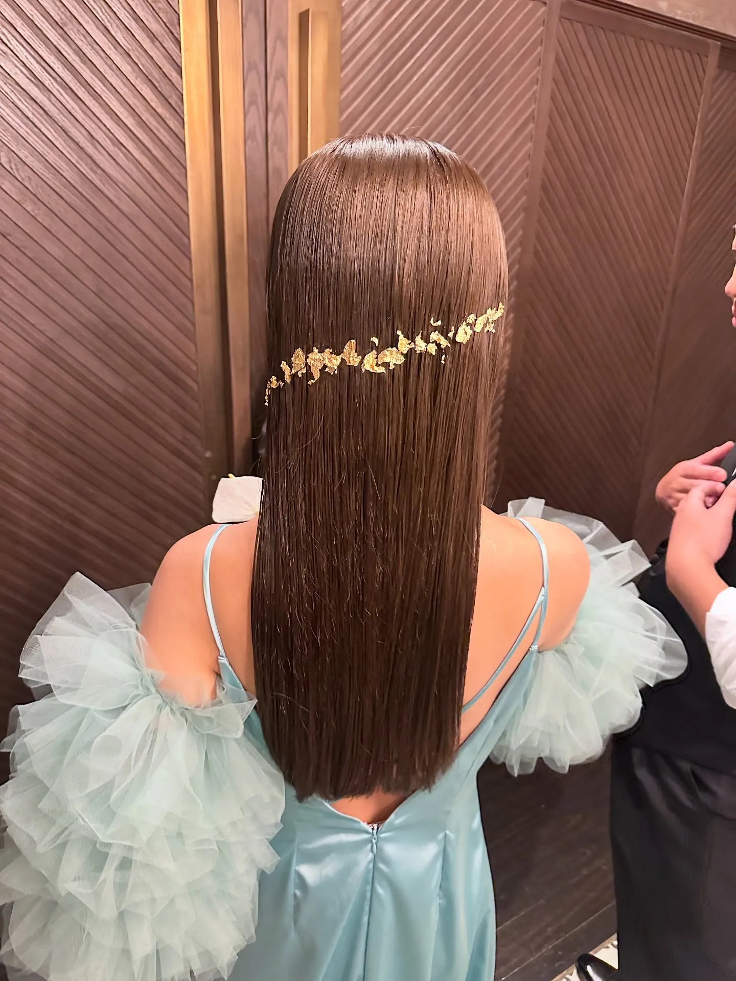 Pin-straight hair with a slim gold vine across the back