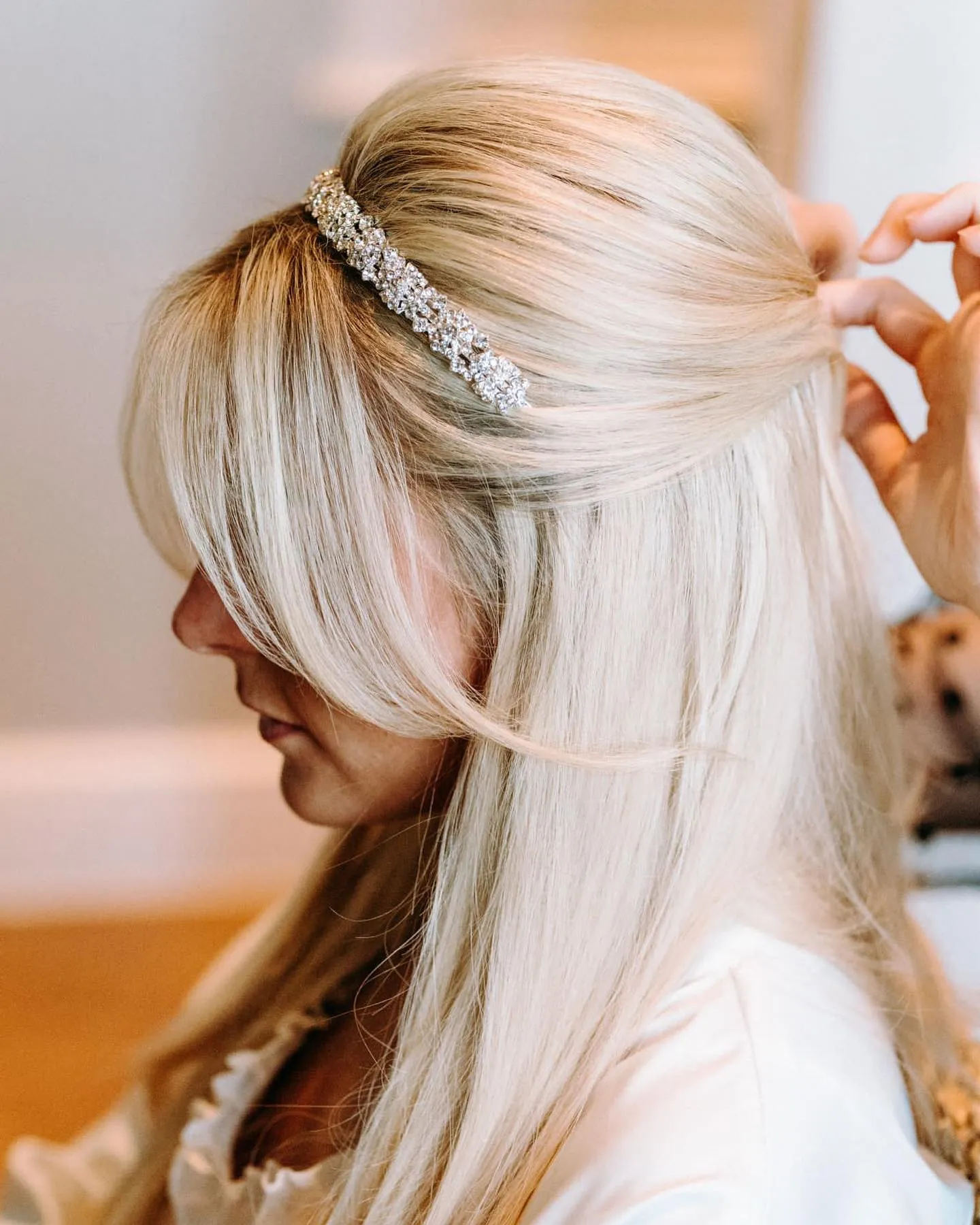 Blonde straight half-up hairstyle with jeweled barrette