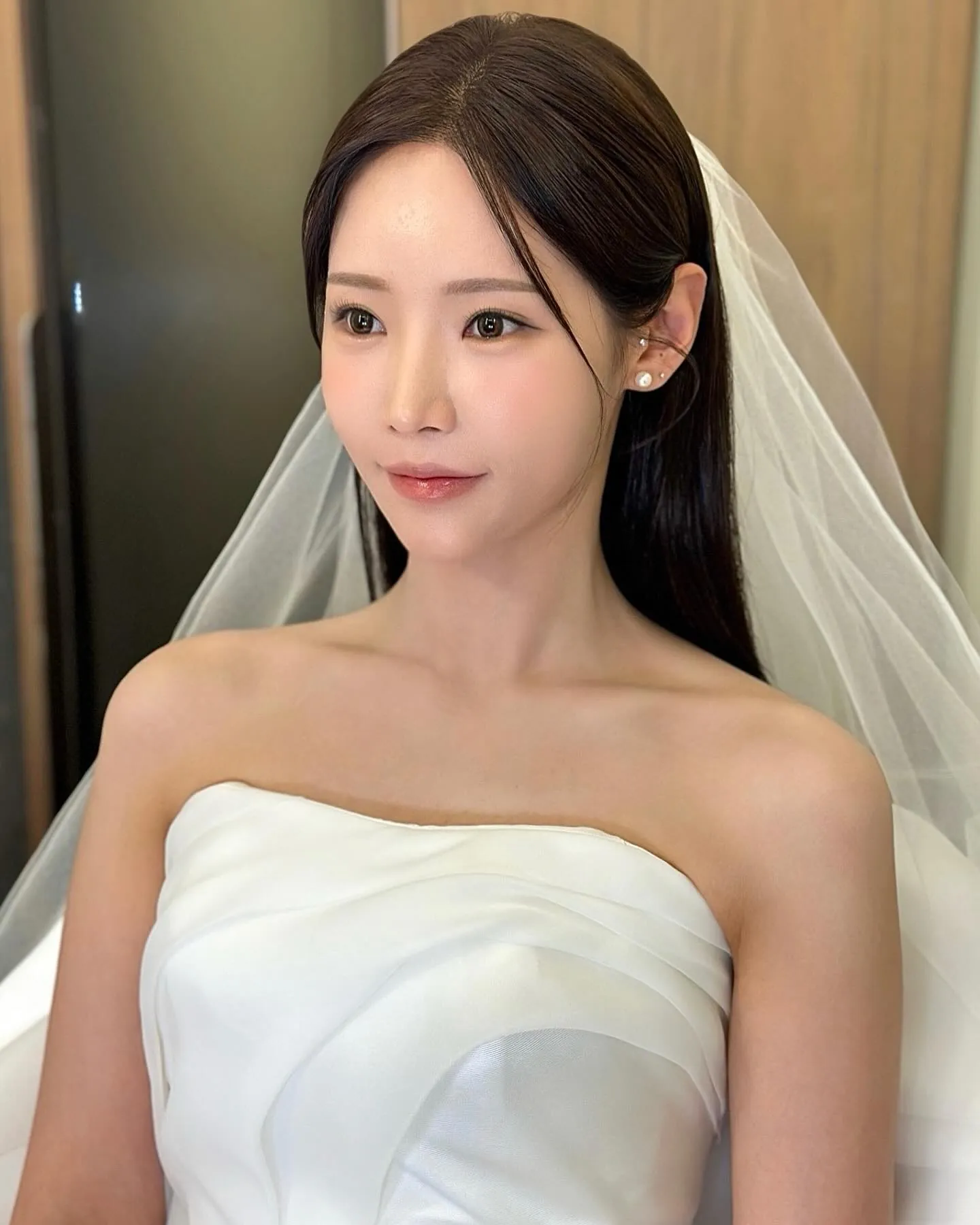 Sleek center-parted straight bridal hair with veil