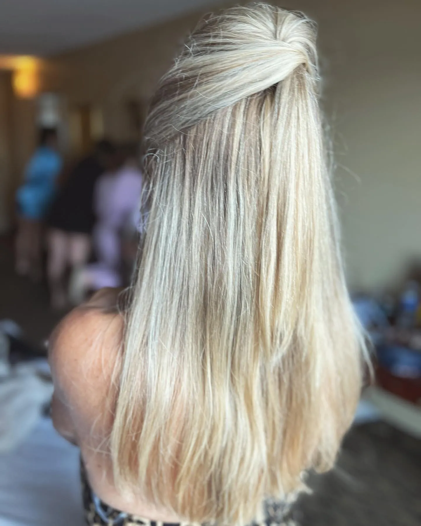 Blonde straight hair with a softly lifted half-up twist