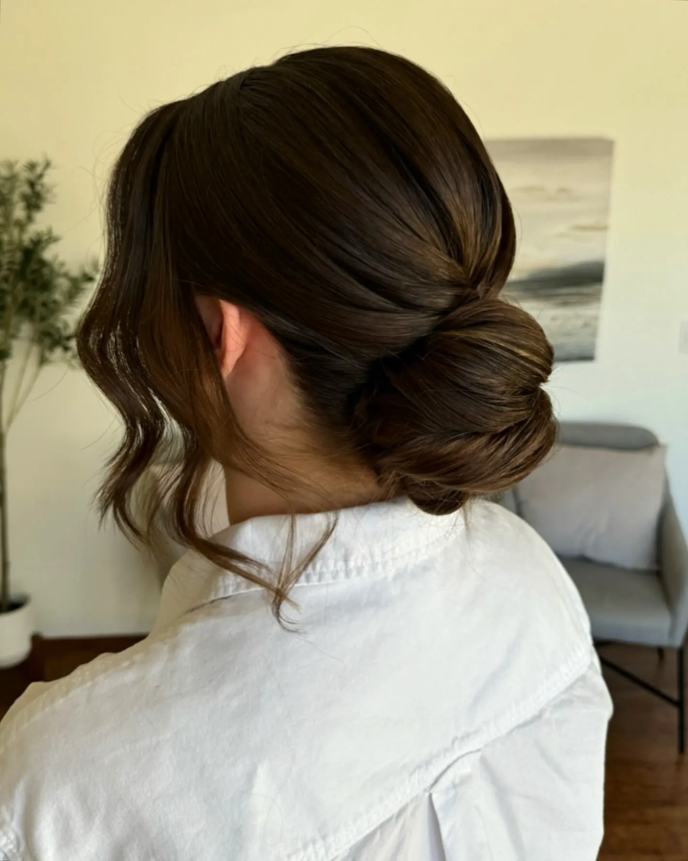 Smooth brunette low bun with soft face-framing pieces