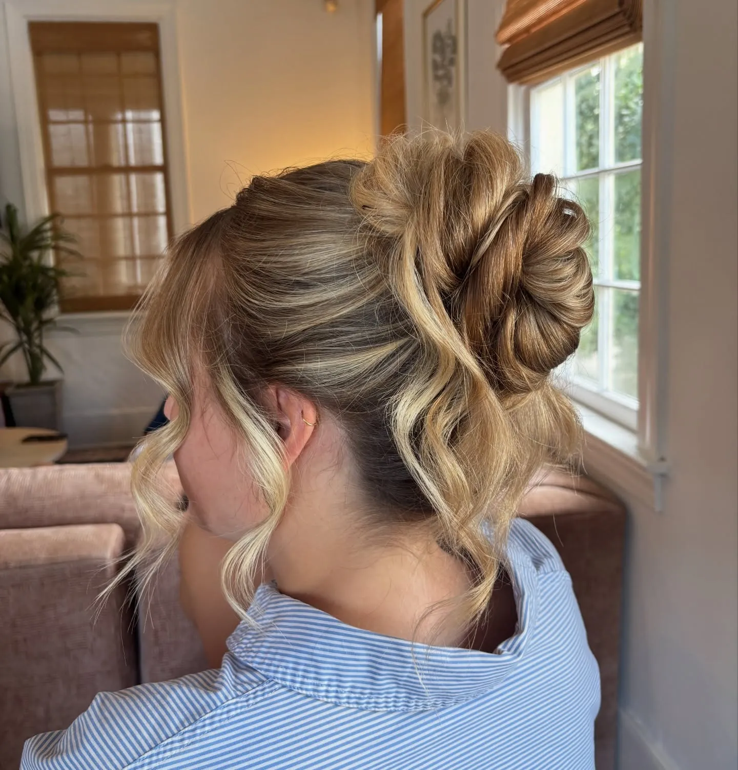 Tousled high bun with loose curled face-framing pieces