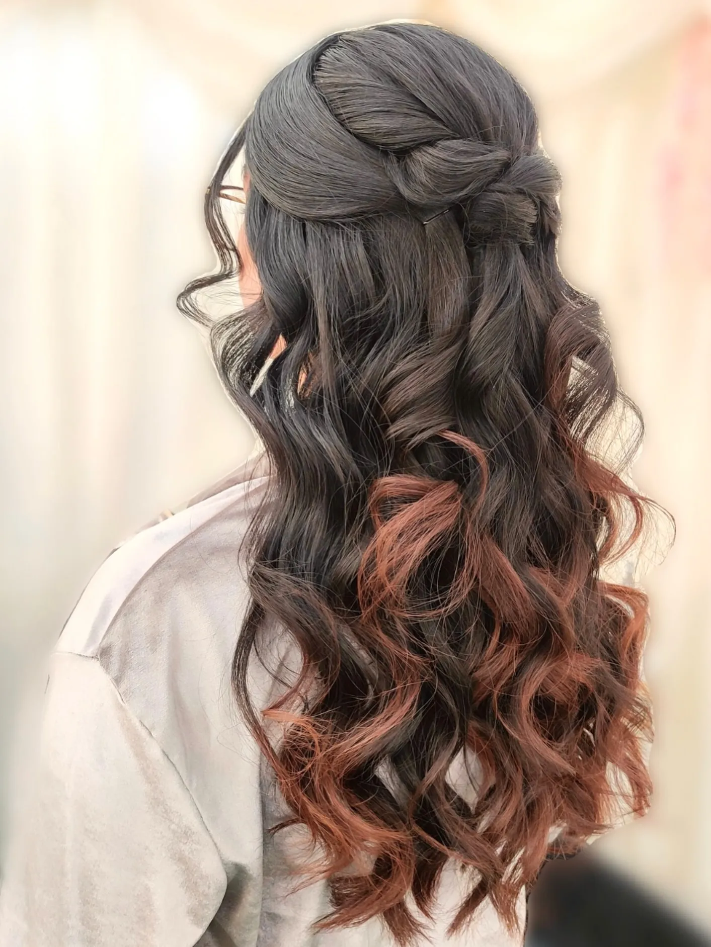 Dark half-up hairstyle with braided crown and curled lengths
