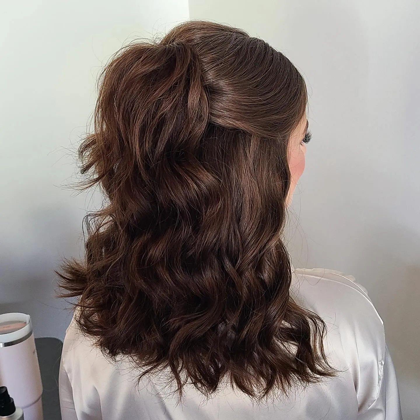 Shoulder-length brunette half-up hairstyle with loose waves