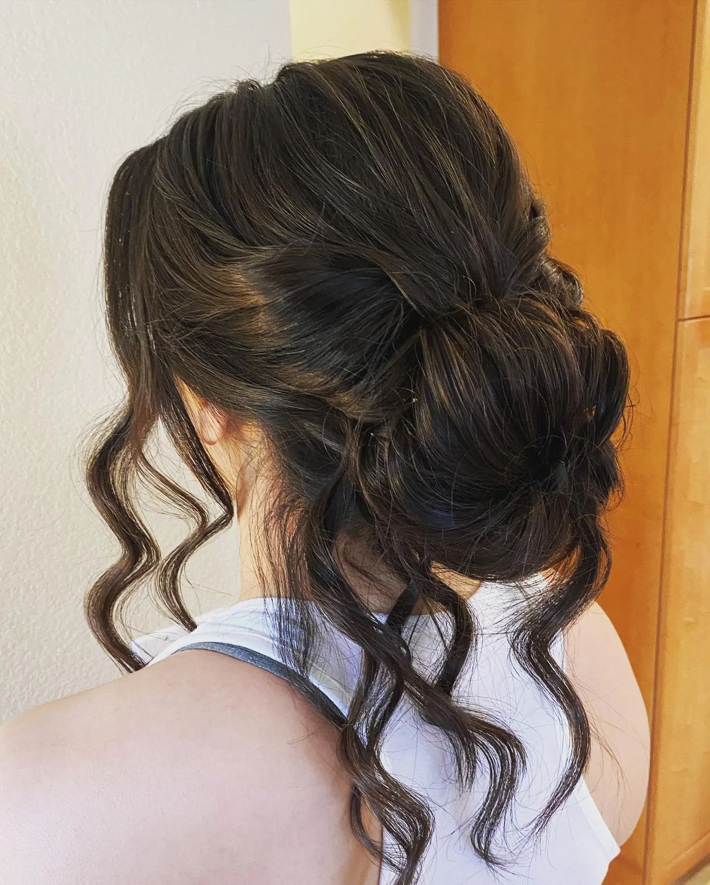 Loose dark bridal updo with curled tendrils