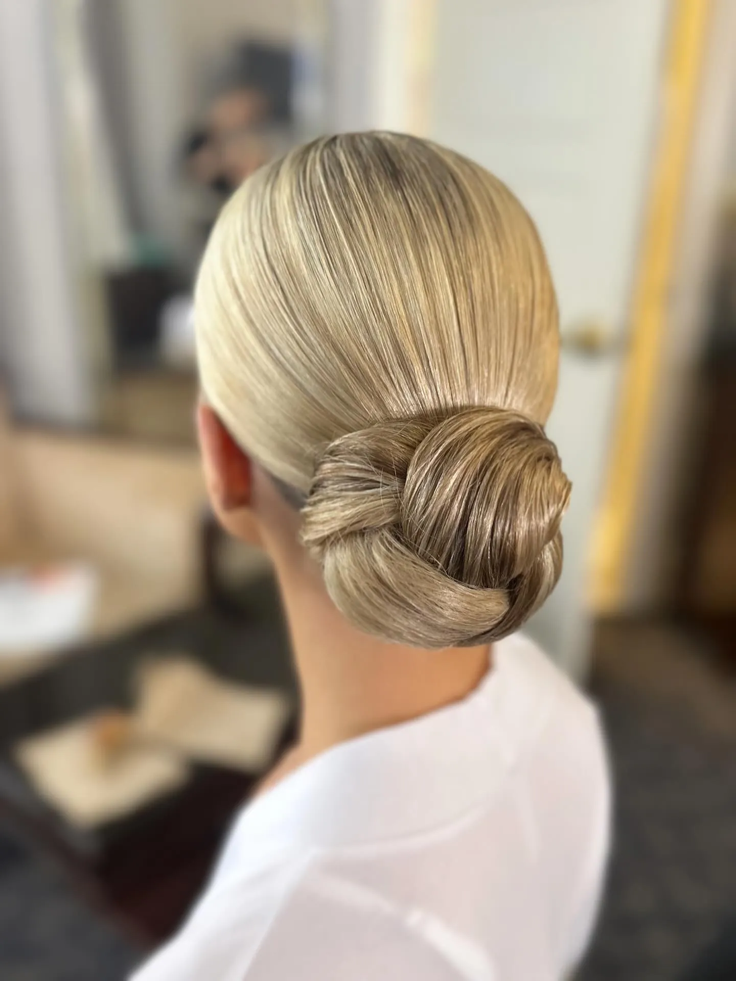 Sleek blonde low chignon with wrapped knot detail