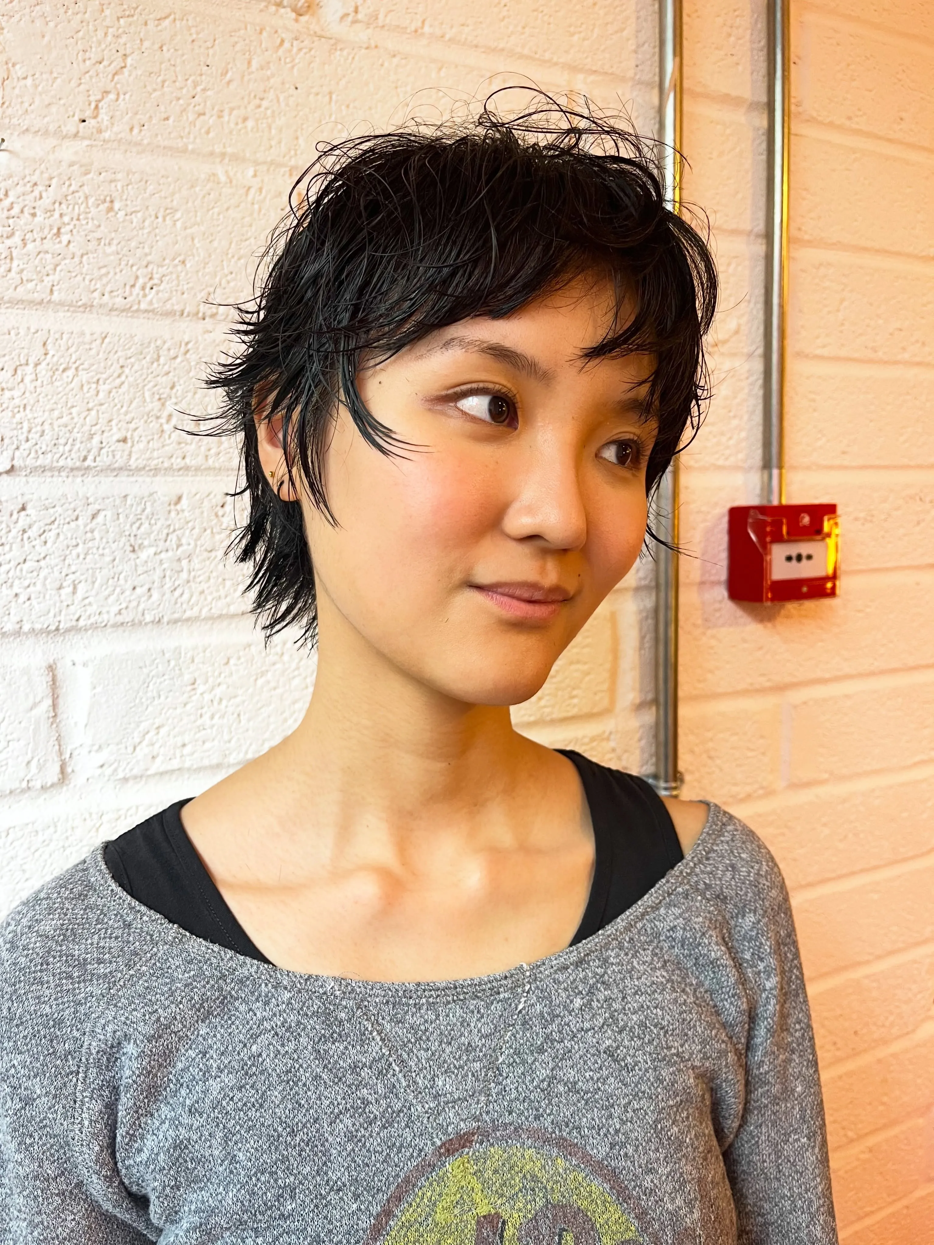 Choppy black wet-look pixie with textured ends
