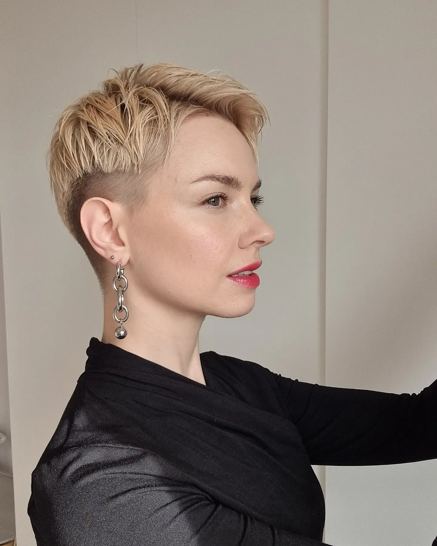 Blonde pixie with closely cropped sides and slicked top