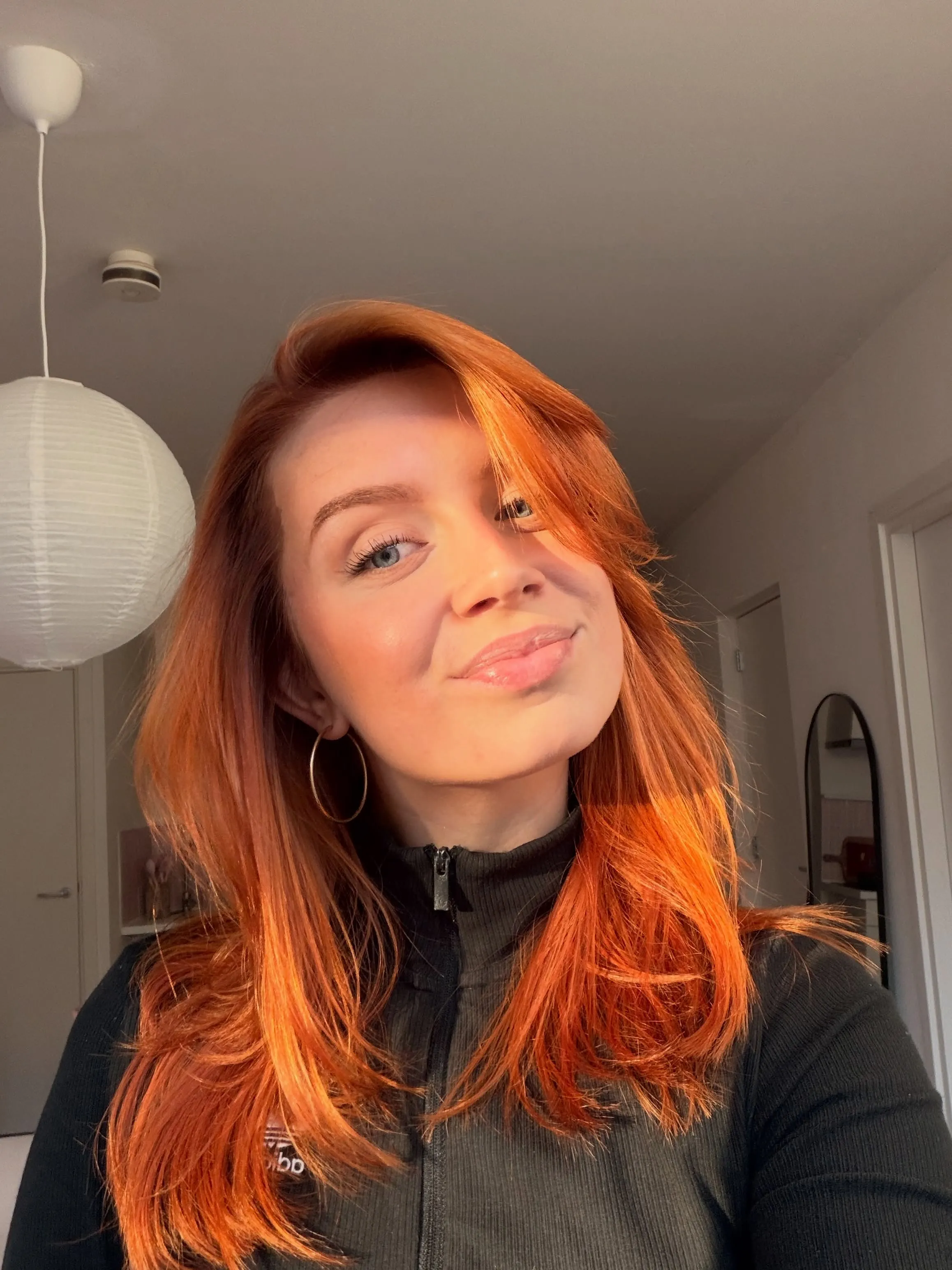 Medium-length bright copper hair with side-swept layered ends