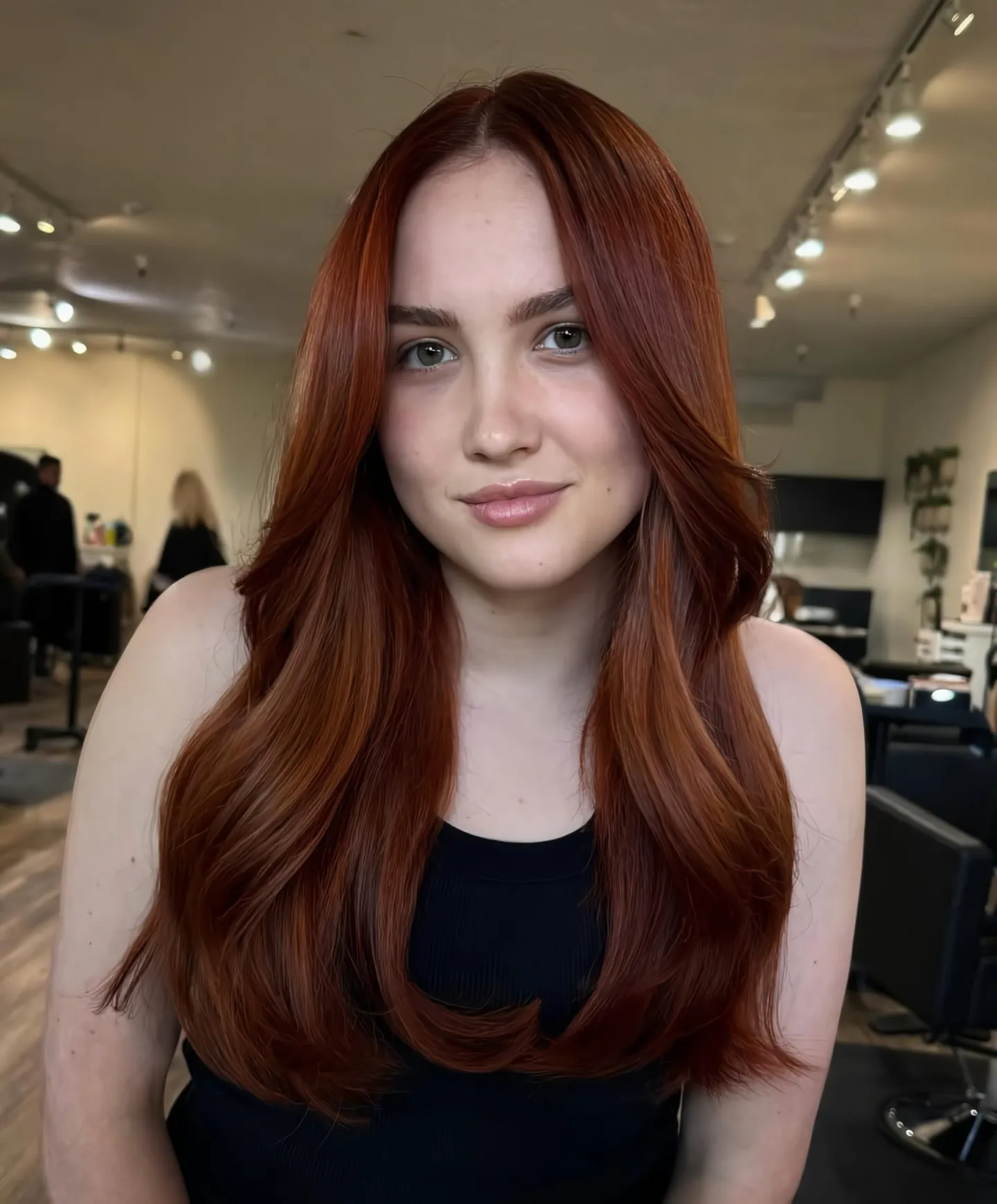 Long deep copper hair with a center part and rounded layered ends