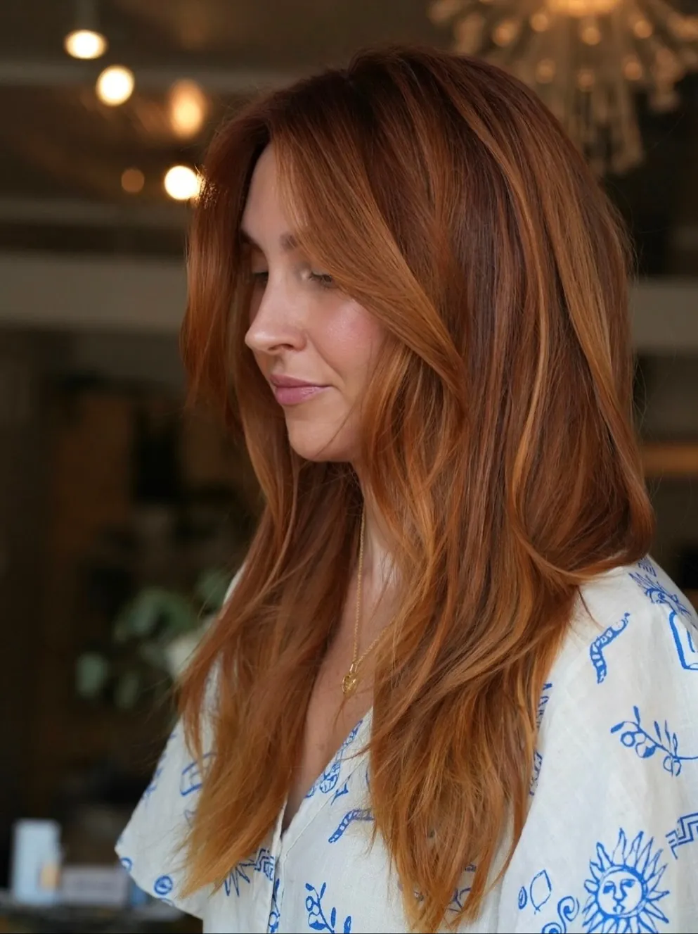 Long copper hair with feathered face-framing layers and softly curved ends