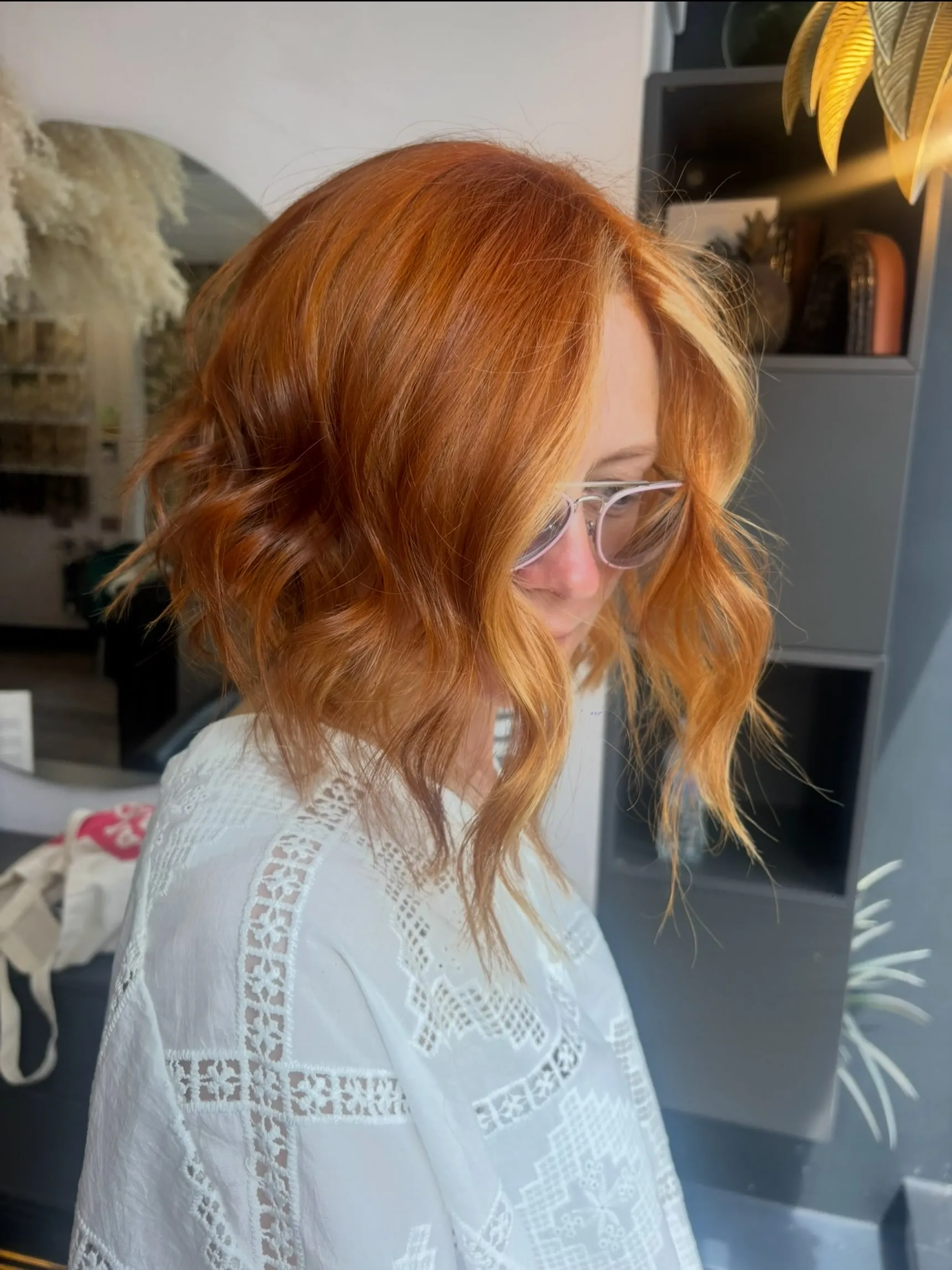 Shoulder-length bright copper lob with loose waves and face-framing pieces